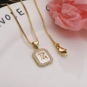 Close-up of gold square pendant with shell inlay and zircon-set letter Z detail.