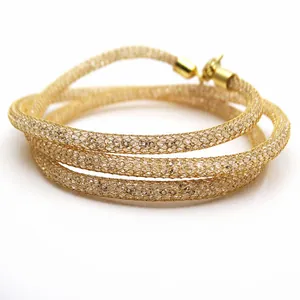 Detailed macro view of a golden metallic mesh tube necklace filled with sparkling crystals