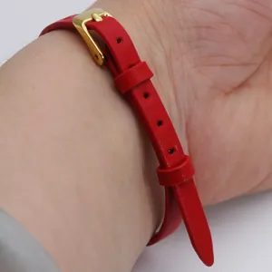 Gros plan détaillé montrant la texture d'un bracelet en cuir rouge de 6 mm et boucle dorée