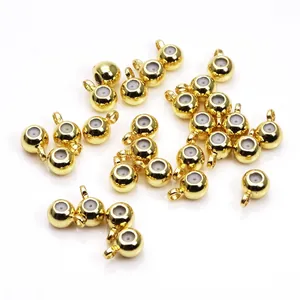 Close-up of 14k gold plated copper positioning beads with silicone rings and loops