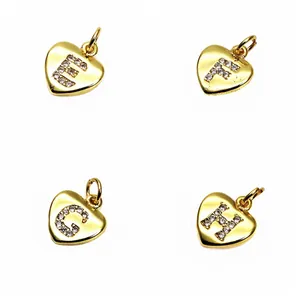 Detail view of heart-shaped gold pendants featuring micro-pave CZ letters E, F, G, and H