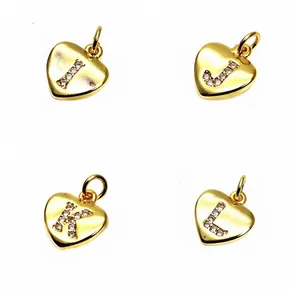 Detailed view of the gold heart pendants micro-inlaid with zircon letters I, J, K, L