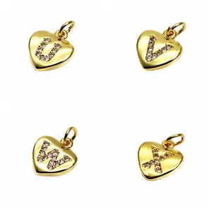 Detailed macro view of gold heart pendants with micro-paved zirconia letters U, V, W, X.