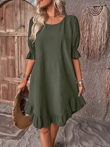 Detailed view of dark green cotton linen dress with ruffle hem and sleeves