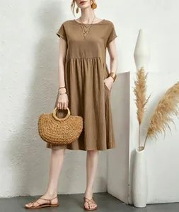 Elegant brown cotton linen loose A-line dress for summer shown on model with straw bag