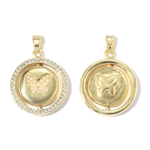 Vue détaillée de deux pendentifs papillon dorés, un avec pierres roses et zircons.