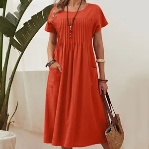 Close-up of a burnt orange cotton linen midi dress showing pleats and side pockets