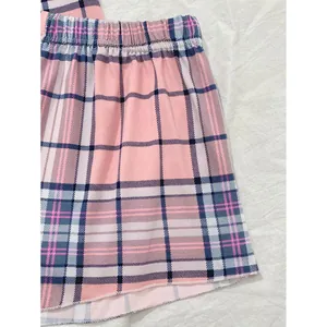 Primo piano di pantaloncini da pigiama a quadri rosa con elastico in vita e tessuto morbido.