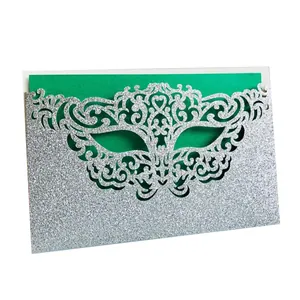 Detail view of silver glitter invitation with laser-cut mask design and green insert