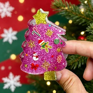 Detailed view of a pink glitter Christmas tree hair claw clip featuring festive charms