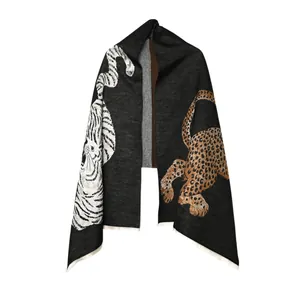Detail view of grey jacquard scarf with large tiger and leopard animal patterns.