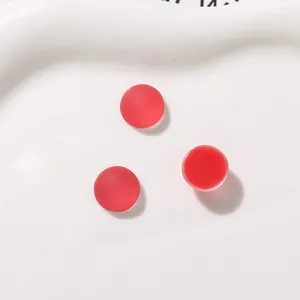 Primo piano di cabochon in resina rossa opaca da 12 mm per orecchini e accessori fai-da-te
