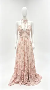 Détail d'une robe longue fleurie rose avec dos nu, ourlet à volants et fente jambe