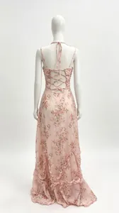 Vue arrière d'une robe longue à fleurs rose avec dos nu lacé et ourlet à volants