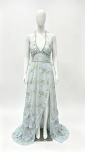 Robe longue fleurie bleu clair avec licou, fente à volants et détails perlés.