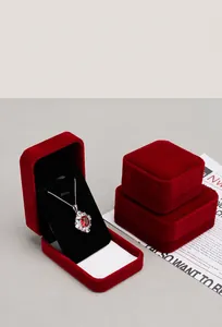 Macro view of premium red velvet jewelry boxes with rounded corners and a pendant