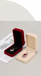 Close-up detail of premium rounded velvet jewelry boxes in red and beige showing necklaces