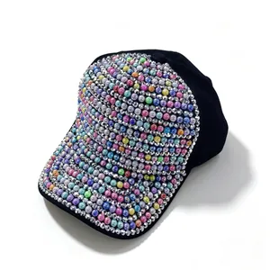 Dettaglio di perle colorate e strass scintillanti su un cappellino da baseball nero moda