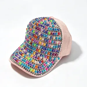 Dettaglio di un cappello rosa con perle colorate e decorazioni in strass scintillanti