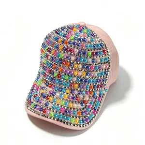 Dettaglio di un cappello da baseball rosa con perle colorate e strass luccicanti di lusso