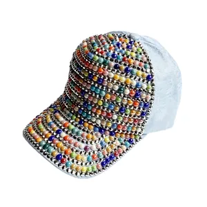 Elegante berretto da baseball con perle colorate e strass su tessuto blu chiaro.