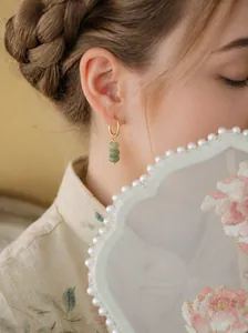 Detailaufnahme eines asiatischen Models mit eleganten grünen Dongling-Stein-Ohrringen