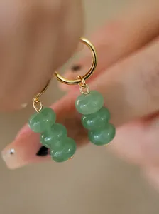 Nahaufnahme von handgefertigten Ohrringen aus grünem Aventurinstein mit Goldfinish