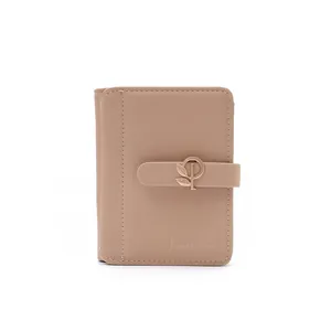 Close-up of beige PU leather wallet featuring an elegant gold leaf buckle detail