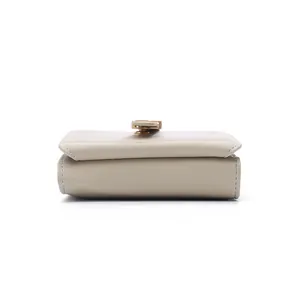 Side view detail of a beige PU leather women's short wallet with decorative leaf clasp