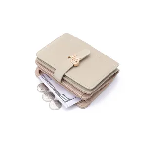 Detailed view of a beige PU leather women's short wallet featuring a gold leaf buckle and coins