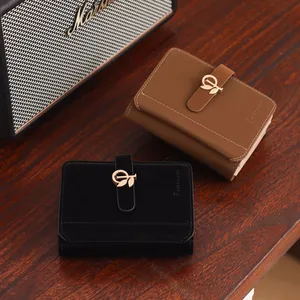 Detailed view of women's short PU leather wallets in black and brown with leaf buckle.