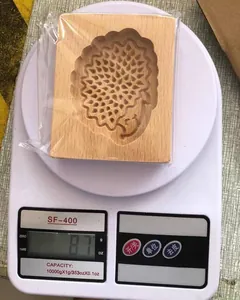 Gewichtsdetail der hölzernen Kekskunstform mit Igelmuster auf Waage bei 87 Gramm