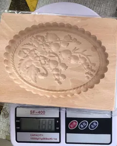 Detailansicht einer handgefertigten Holz-Plätzchenform, die 188g auf der Küchenwaage anzeigt
