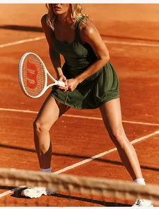 Breathable dark green tennis dress shown in action on a clay court for fitness