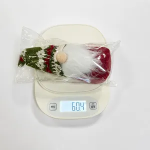 Weight measurement showing a Christmas gnome doll at 60.4g in plastic packaging