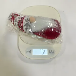 Detailed weight measurement of a Christmas gnome doll showing 75.4 grams on a scale