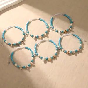 Handmade Bohemian woven bracelet set featuring blue turquoise beads and natural sea shells