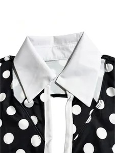 Dettaglio del colletto a revers bianco e del motivo a pois su una tuta nera sexy.