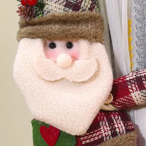 Détail rapproché d'une embrasse de rideau en peluche Père Noël avec motif écossais