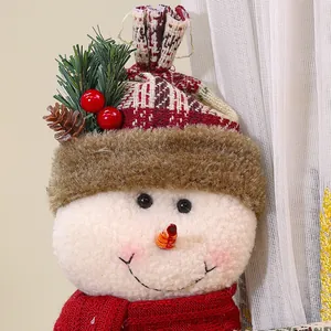Gros plan d'une embrasse de rideau bonhomme de neige en peluche avec bonnet et écharpe.