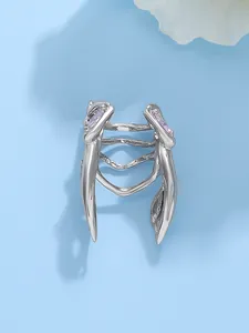 Detailed view of a creative silver beetle ring with purple stones on blue backdrop
