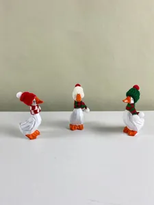 Trois figurines d'oies blanches avec bonnets de Noël et écharpes pour la maison
