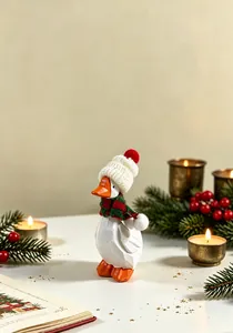Détail d'un ornement d'oie blanche en bois fait main avec un bonnet et une écharpe.