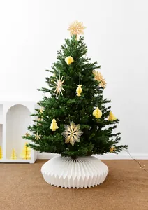 Detailed view of white pleated Christmas tree skirt base in a cozy holiday setting.