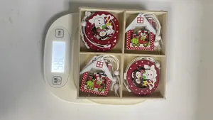 Detailed view of boxed Christmas wooden ornaments weighing 78.5g on a digital scale