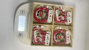 Boxed set of 4 Christmas wooden ornaments weighing 181.1 grams on a digital scale