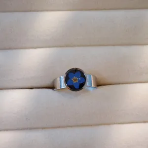 Nahaufnahme einer echten blauen vergissmeinnicht Trockenblume in einem Edelstahlring