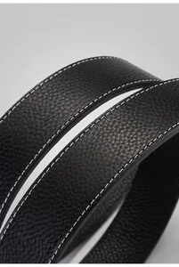 Macro detail of premium black lychee grain leather belt strap with white contrast stitching