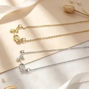 Detailed view of gold and silver minimalist tulip necklaces on a decorative background.