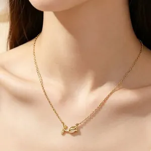 Detailed close-up of a gold tulip pendant necklace with a chalcedony stone on a woman's neck